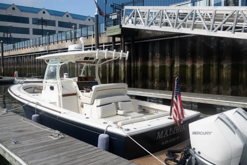 Malihini Yacht Photos Pics 2019 Hunt Yachts 32 Center Console docked, featuring a Mercury engine and American flag.