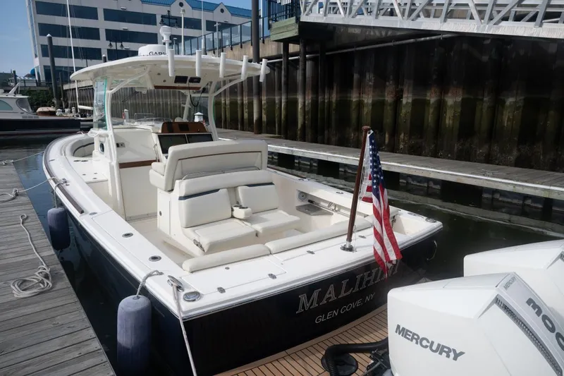 Malihini Yacht Photos Pics 2019 Hunt Yachts 32 Center Console docked, featuring sleek design and American flag.