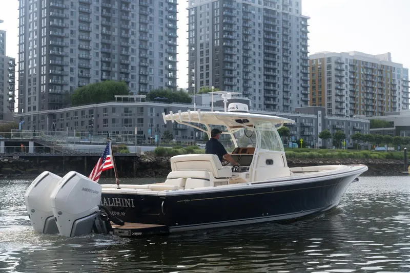 Malihini Yacht Photos Pics 2019 Hunt Yachts 32 Center Console cruising near urban waterfront with modern buildings.
