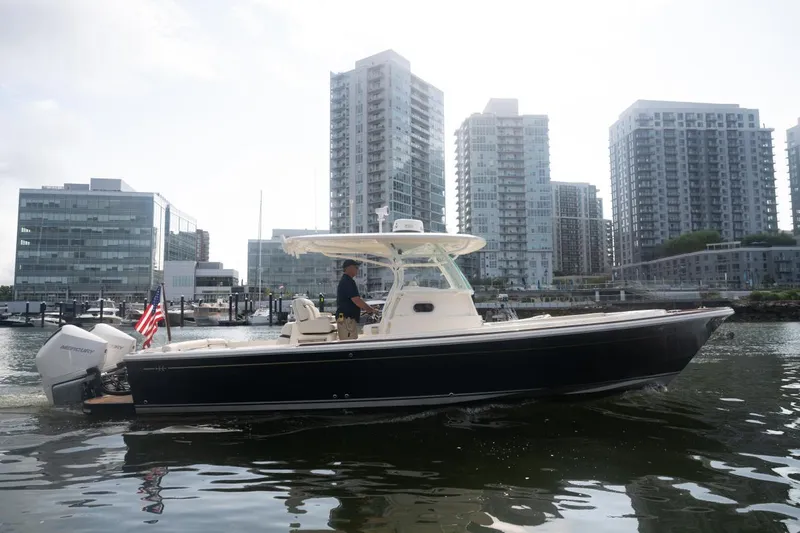 Malihini Yacht Photos Pics 2019 Hunt Yachts 32 Center Console cruising near urban waterfront with modern buildings.