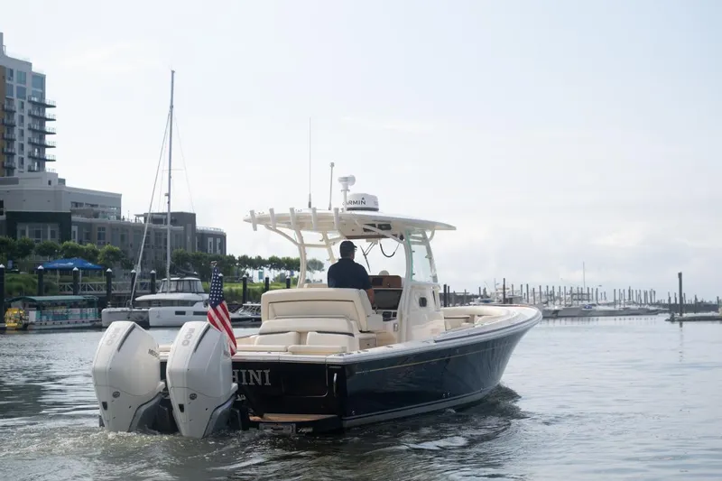 Malihini Yacht Photos Pics 2019 Hunt Yachts 32 Center Console cruising in a marina, featuring twin outboard engines.