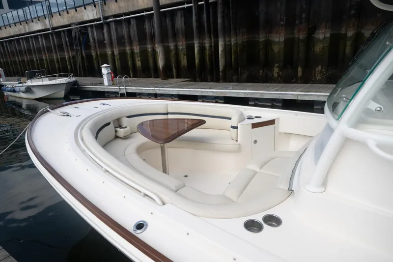 Malihini Yacht Photos Pics 2019 Hunt Yachts 32 Center Console with elegant seating and wooden table at dock.