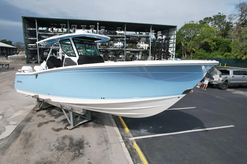  Yacht Photos Pics 2023 Blackfin 332 CC boat in light blue, parked on a trailer in a marina.