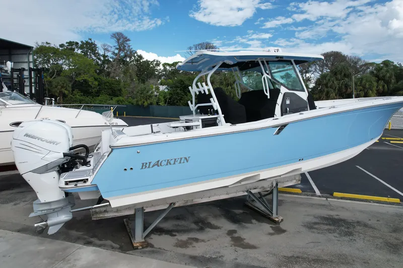  Yacht Photos Pics 2023 Blackfin 332 CC boat with Mercury engine, displayed outdoors on a stand.