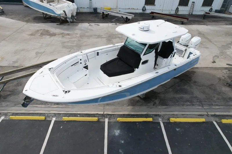  Yacht Photos Pics 2023 Blackfin 332 CC boat in a marina, featuring sleek design and dual engines.