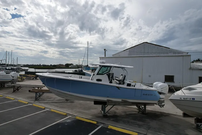  Yacht Photos Pics 2023 Blackfin 332 CC boat on display at a marina under cloudy skies.