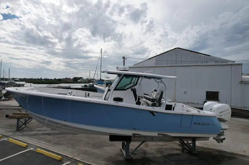  Yacht Photos Pics 2023 Blackfin 332 CC boat on display at a marina with cloudy sky backdrop.