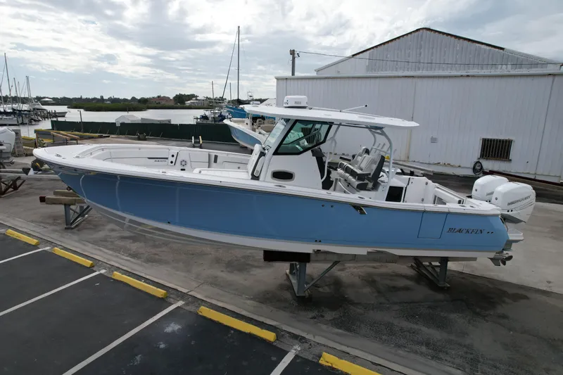  Yacht Photos Pics 2023 Blackfin 332 CC boat in marina, light blue hull, parked on a stand.