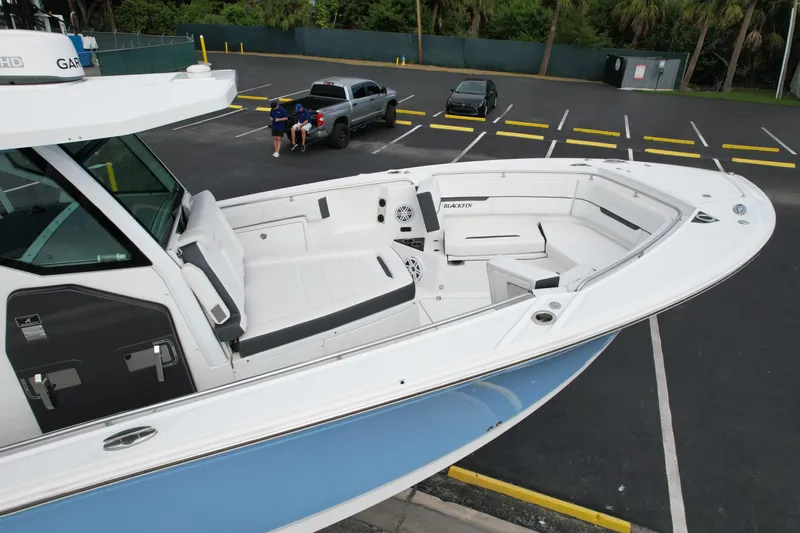  Yacht Photos Pics 2023 Blackfin 332 CC boat with spacious seating, parked in a lot.