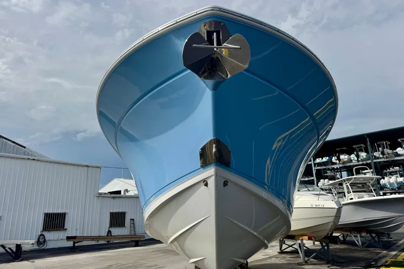  Yacht Photos Pics 2023 Blackfin 332 CC boat with blue hull, docked in a marina.