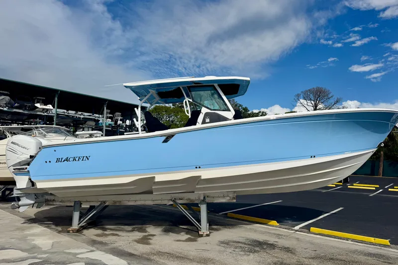  Yacht Photos Pics 2023 Blackfin 332 CC boat in light blue, displayed on a stand under a clear sky.