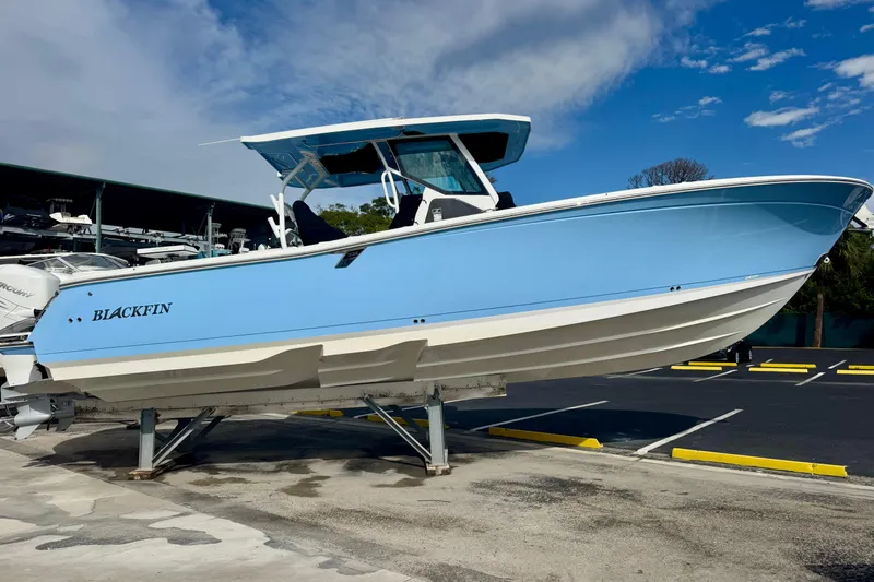  Yacht Photos Pics 2023 Blackfin 332 CC boat in light blue, displayed on a stand outdoors.