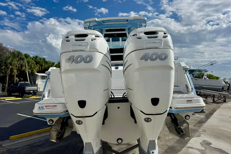 Yacht Photos Pics 2023 Blackfin 332 CC boat with twin 400 horsepower engines, docked under a cloudy sky.