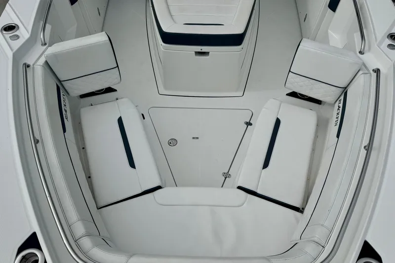  Yacht Photos Pics 2023 Blackfin 332 CC boat interior with white cushioned seating and storage compartments.