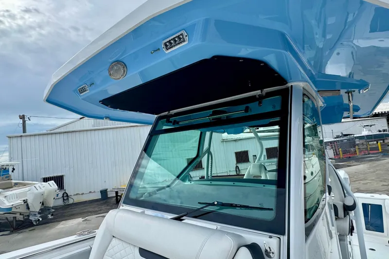  Yacht Photos Pics 2023 Blackfin 332 CC boat with blue hardtop and windshield, docked at marina.