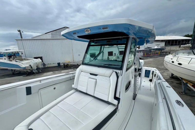  Yacht Photos Pics 2023 Blackfin 332 CC boat with sleek design and spacious seating at a marina.