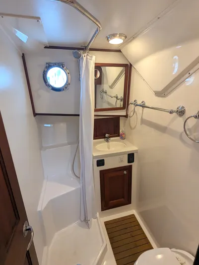 Watershed Yacht Photos Pics 2014 Nordic Tug 34 Pilothouse bathroom with shower, sink, and porthole window.