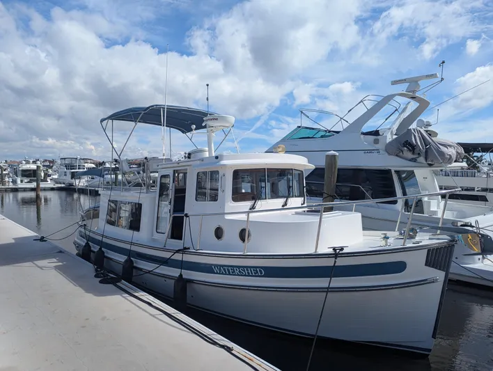 Watershed Yacht Photos Pics 2014 Nordic Tug 34 Pilothouse docked at marina under cloudy sky.