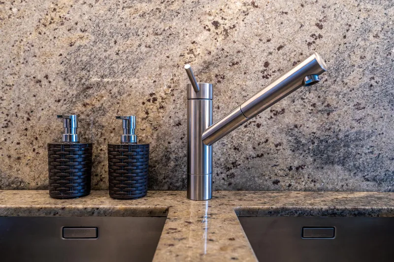 Blue Angel Yacht Photos Pics Modern kitchen sink with sleek faucet and soap dispensers on granite countertop.