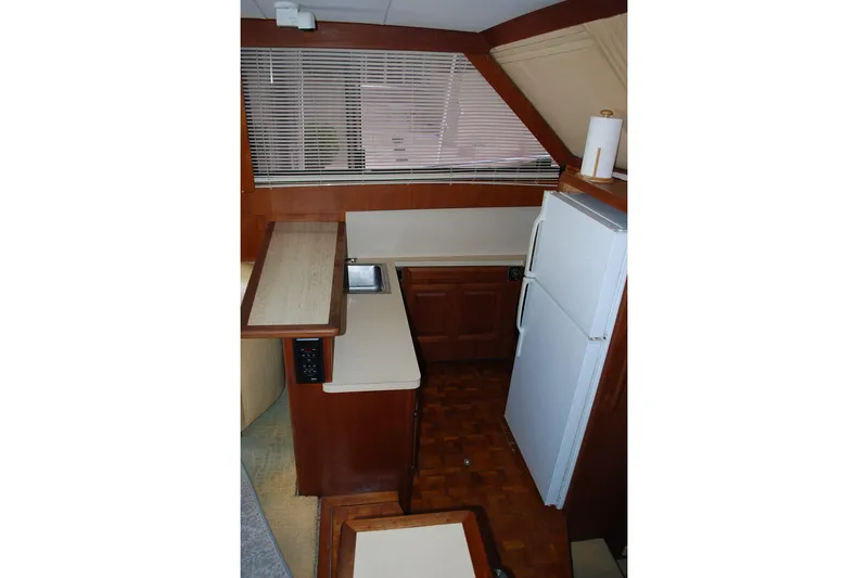 2 Jay's Yacht Photos Pics 1988 Viking 45 Convertible yacht kitchen with wood cabinetry, sink, and refrigerator.