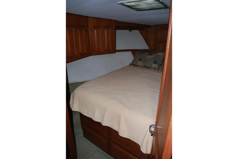 2 Jay's Yacht Photos Pics Cozy bedroom in 1988 Viking 45 Convertible yacht with wooden cabinets and comfortable bedding.