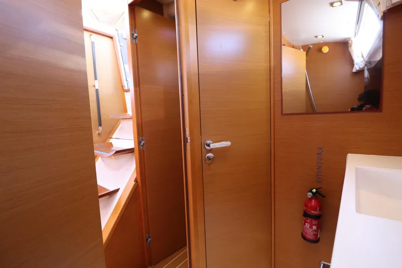 Marley 2 Yacht Photos Pics Interior of 2012 Jeanneau Sun Odyssey 509 yacht, featuring wooden cabinetry and a fire extinguisher.