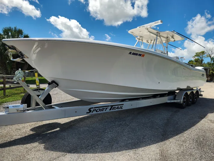  Yacht Photos Pics 2013 Invincible 36 Open Fisherman boat on trailer under blue sky.