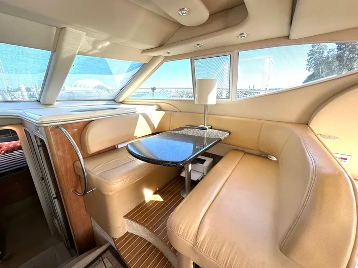 The Mystic Yacht Photos Pics Interior of 2001 Maxum 4600 SCB yacht with beige seating and sleek table.