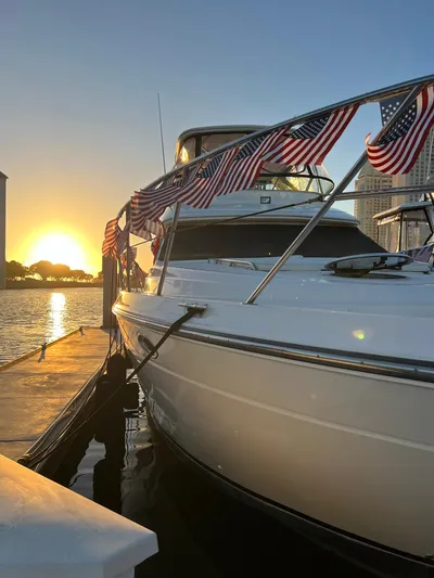 The Mystic Yacht Photos Pics 2001 Maxum 4600 SCB Limited Edition yacht docked at sunset, adorned with American flags.