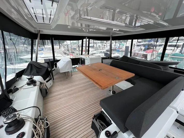  Yacht Photos Pics Spacious interior of 2023 Lagoon 55 yacht with modern seating and wooden table.