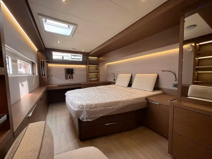  Yacht Photos Pics Luxurious 2023 Lagoon 55 yacht bedroom with modern wood finishes and ambient lighting.