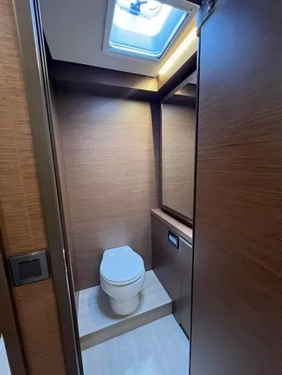  Yacht Photos Pics Modern bathroom in 2023 Lagoon 55 yacht with skylight and wooden finishes.
