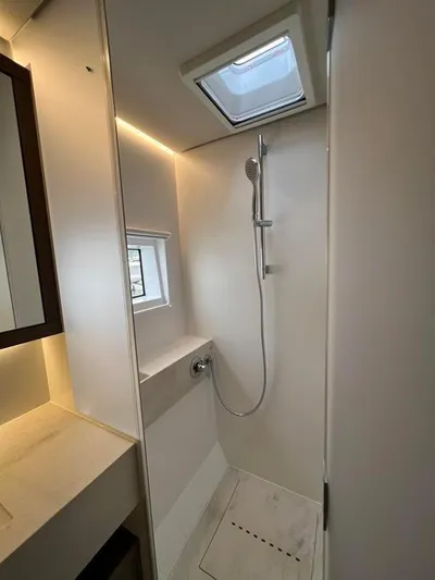  Yacht Photos Pics Modern bathroom in 2023 Lagoon 55 yacht with skylight and sleek shower design.