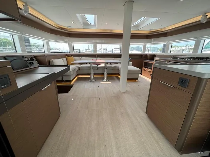  Yacht Photos Pics Luxurious interior of 2023 Lagoon 55 yacht with modern furnishings and panoramic windows.