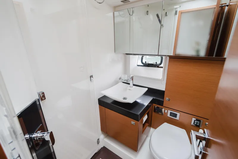 Worldwide Yacht Photos Pics Luxurious bathroom in 2014 Prestige 620 Fly yacht with modern fixtures and wood accents.