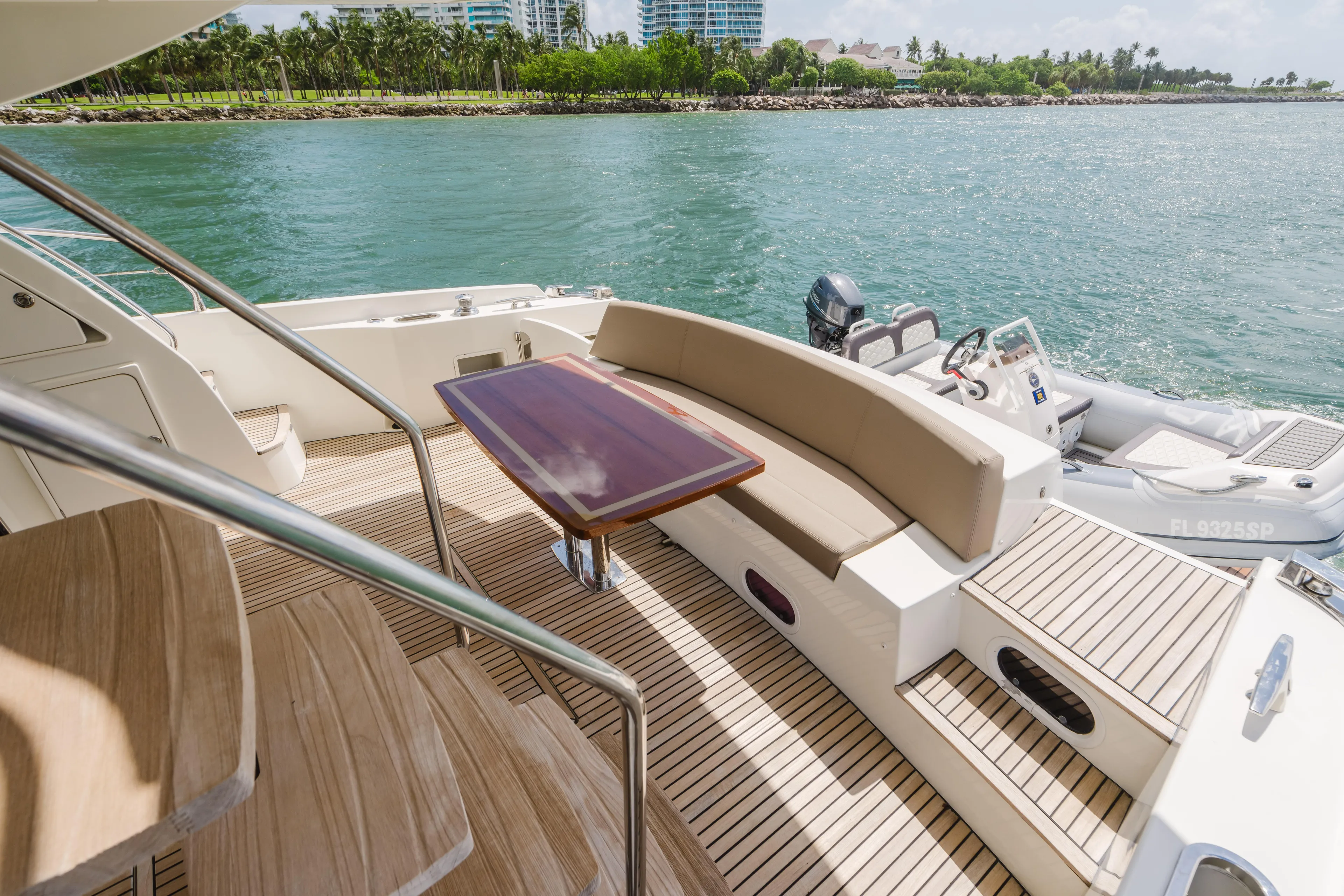 Worldwide Yacht Photos Pics Luxurious 2014 Prestige 620 Fly yacht deck with seating, table, and scenic waterfront view.