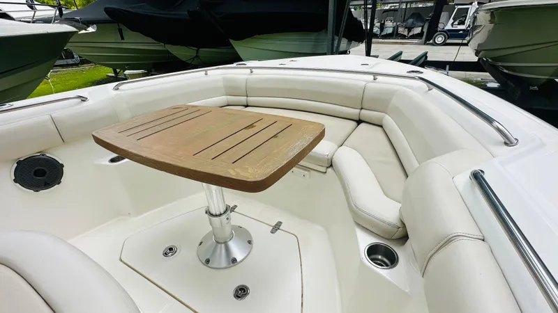  Yacht Photos Pics 2020 Boston Whaler 330 Outrage boat with cushioned seating and wooden table.
