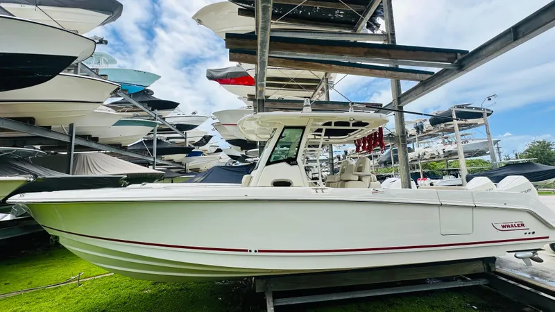  Yacht Photos Pics 2020 Boston Whaler 330 Outrage boat in storage, surrounded by other vessels.