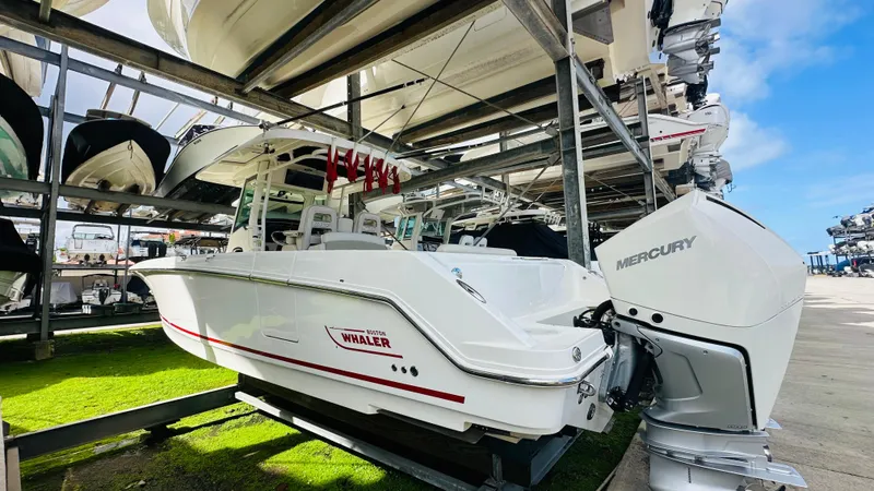  Yacht Photos Pics 2020 Boston Whaler 330 Outrage boat with Mercury engine in storage facility.
