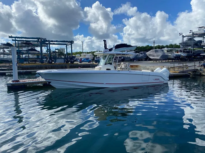  Yacht Photos Pics 2020 Boston Whaler 330 Outrage boat docked in a marina under a cloudy sky.