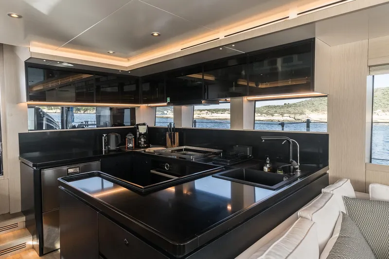 Vanguard Yacht Photos Pics Luxurious kitchen interior of 2023 Naval Yachts XPM 78 with sleek black countertops.