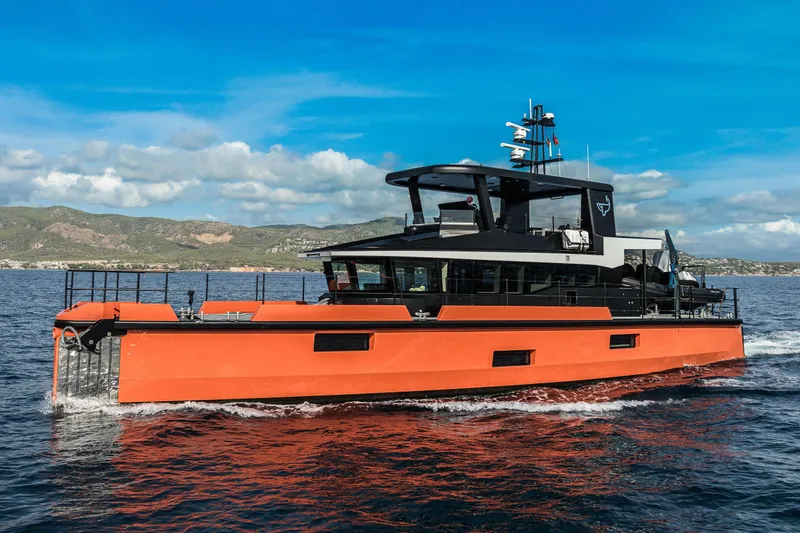 Vanguard Yacht Photos Pics 2023 Naval Yachts XPM 78 cruising on open water, vibrant orange hull, scenic background.