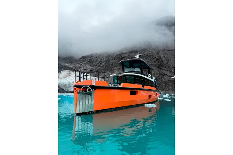 Vanguard Yacht Photos Pics Orange Naval Yachts XPM 78, 2023 model, in icy waters with mountainous backdrop.