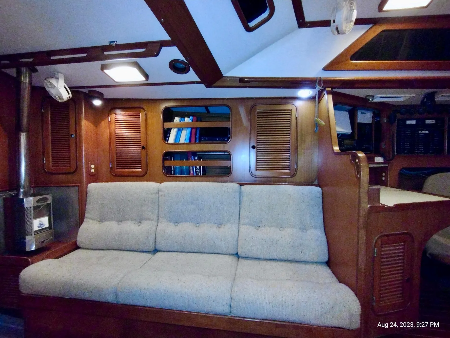 Interior of 1983 Norseman 447 CC Cutter with cozy seating and wooden cabinetry.