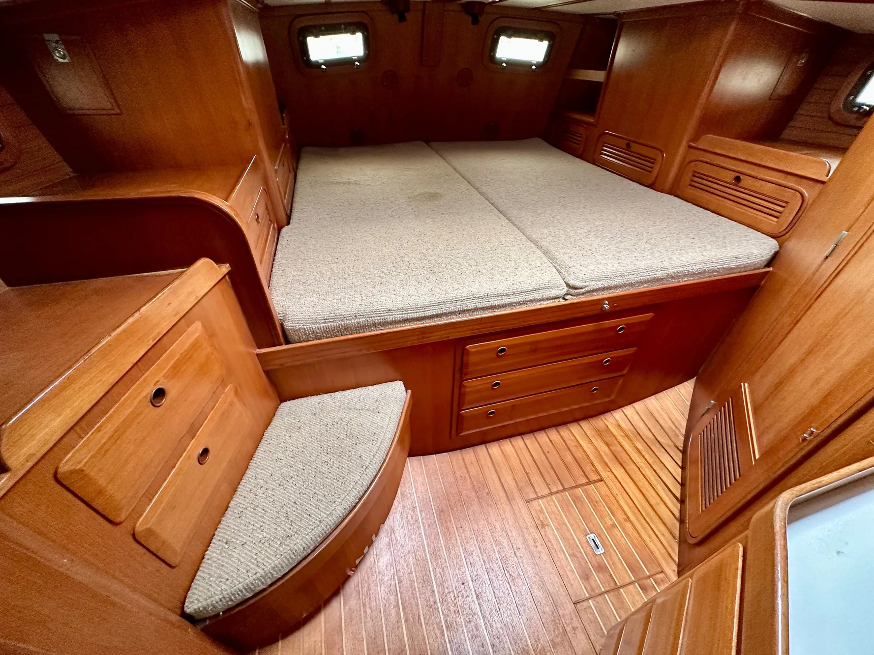 Cozy cabin interior of 1983 Norseman 447 CC Cutter with wooden furnishings and bed.