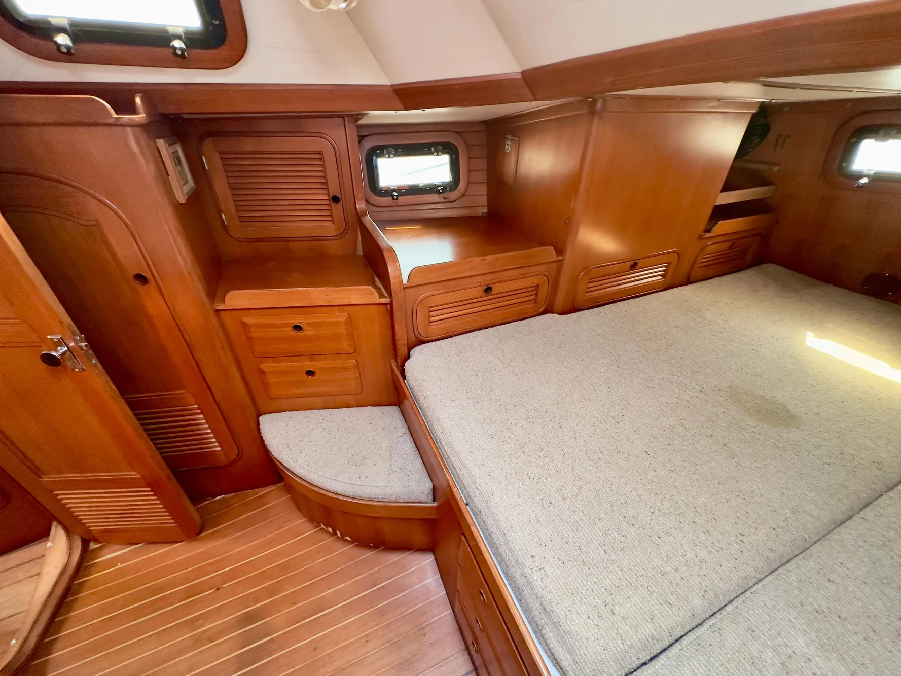 Interior of 1983 Norseman 447 CC Cutter, featuring wooden cabinetry and a cozy bed.