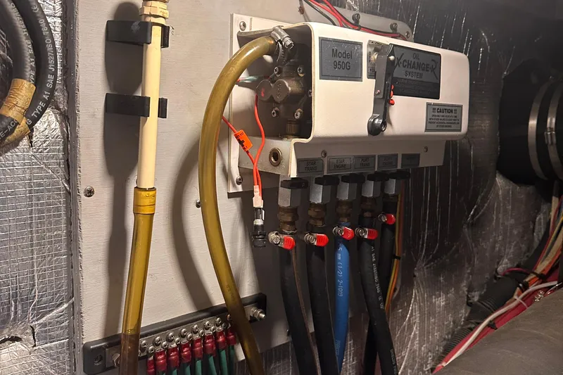 Double Eagle Yacht Photos Pics 2004 Silverton 42 Convertible engine room with oil exchanger system, Model 950G, and connected hoses.