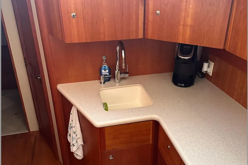 Double Eagle Yacht Photos Pics 2005 Silverton 42 Convertible yacht kitchen with sink, wooden cabinets, and coffee maker.