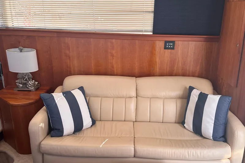 Double Eagle Yacht Photos Pics Luxurious interior of 2005 Silverton 42 Convertible yacht with beige sofa and striped cushions.