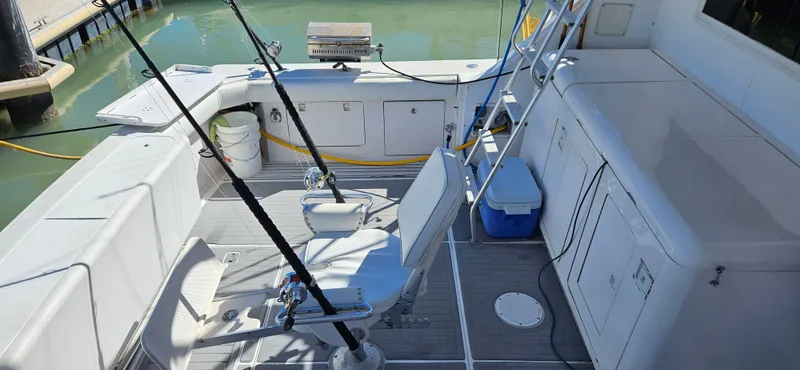 True Grit Yacht Photos Pics 1995 Bertram Convertible boat deck with fishing rods and seating.